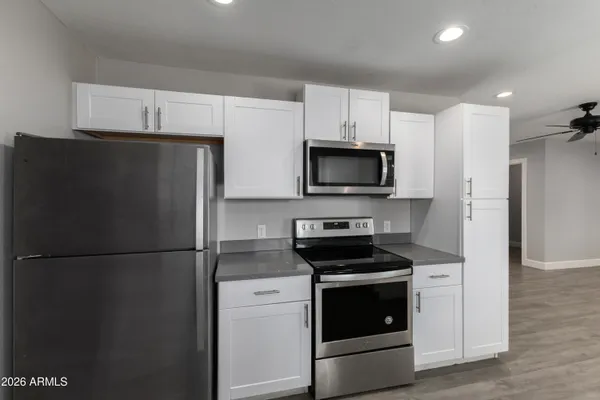 a kitchen with a refrigerator stove and white cabinets