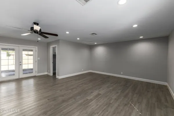 a view of an empty room with a window and wooden floor