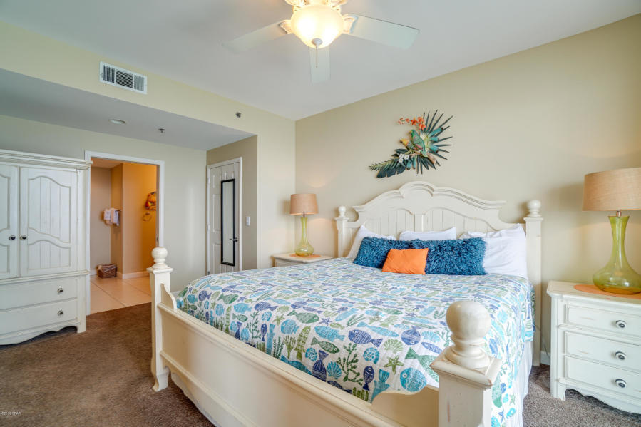 17739 Front Beach Road, Unit 1902W Panama City Beach, FL 32413 - Photo 12 of 30 a bedroom with a bed and a chandelier