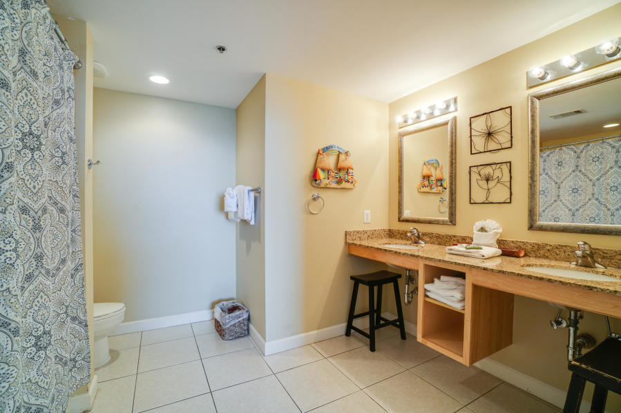 17739 Front Beach Road, Unit 1902W Panama City Beach, FL 32413 - Photo 13 of 30 a view of a bathroom with a sink mirror and toilet
