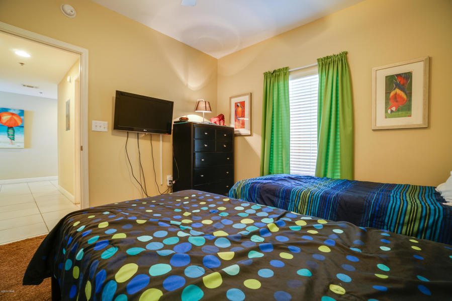 17739 Front Beach Road, Unit 1902W Panama City Beach, FL 32413 - Photo 16 of 30 a bedroom with a bed and a flat tv screen on dresser