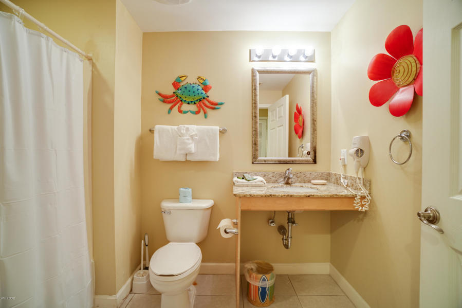 17739 Front Beach Road, Unit 1902W Panama City Beach, FL 32413 - Photo 17 of 30 a bathroom with a sink mirror vanity and toilet