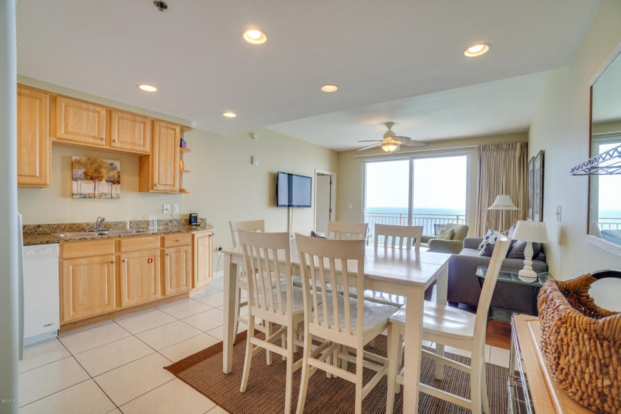 17739 Front Beach Road, Unit 1902W Panama City Beach, FL 32413 - Photo 7 of 30 a large kitchen with kitchen island granite countertop lots of white cabinets appliances and furniture