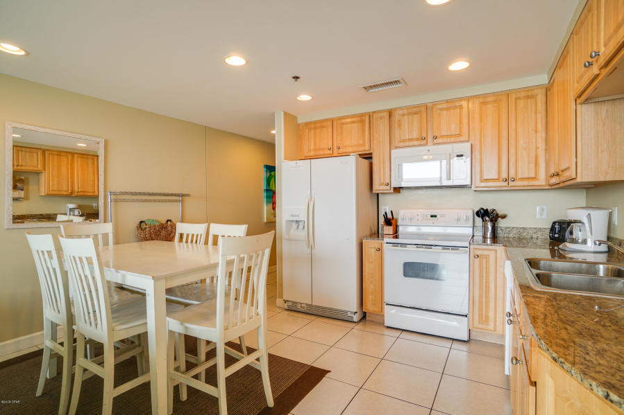 17739 Front Beach Road, Unit 1902W Panama City Beach, FL 32413 - Photo 8 of 30 a kitchen with a sink a refrigerator and cabinets