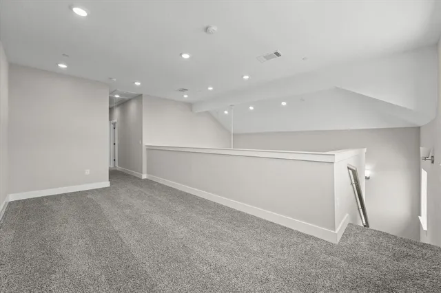 a view of a hallway with a dining table chairs