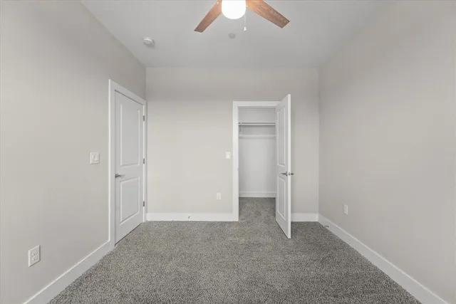 an empty room with chandelier fan