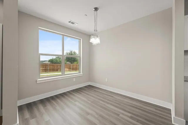 a kitchen with stainless steel appliances kitchen island wooden floors and white cabinets