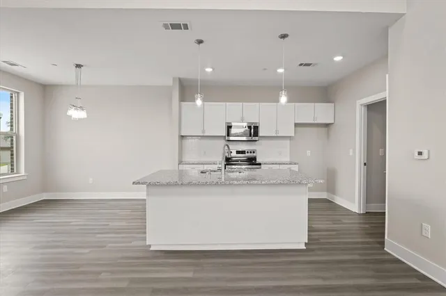 a kitchen with stainless steel appliances granite countertop a sink stove and refrigerator