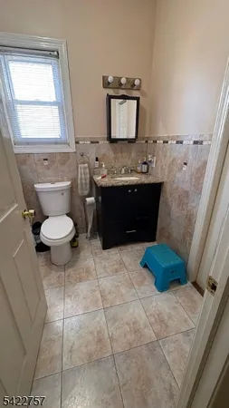 a bathroom with a granite countertop toilet sink and mirror