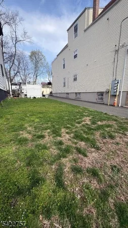 a view of a big yard with an tree and fence