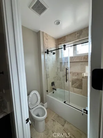 a bathroom with a granite countertop toilet sink and shower