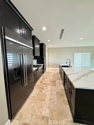 a large kitchen with stainless steel appliances kitchen island a large counter top