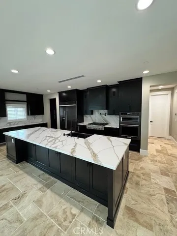 a large kitchen with kitchen island a sink counter space and stainless steel appliances