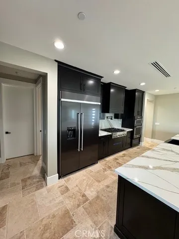 a large kitchen with kitchen island a sink stainless steel appliances and cabinets