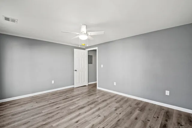 a view of an empty room with wooden floor
