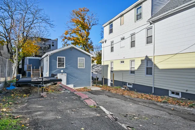 a backyard of a house with garden and tree