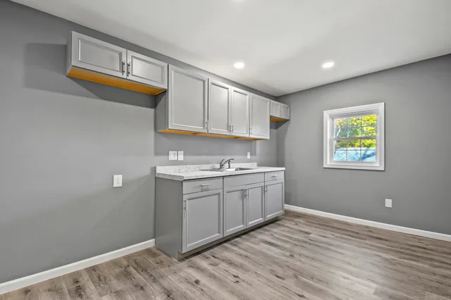 a room with a sink cabinets and wooden floor