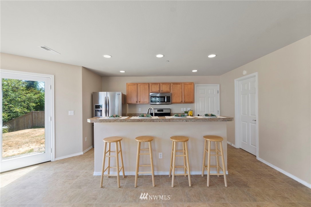 3129 Walker Road DuPont, WA 98327 - Photo 12 of 33 a kitchen with white cabinets and chairs