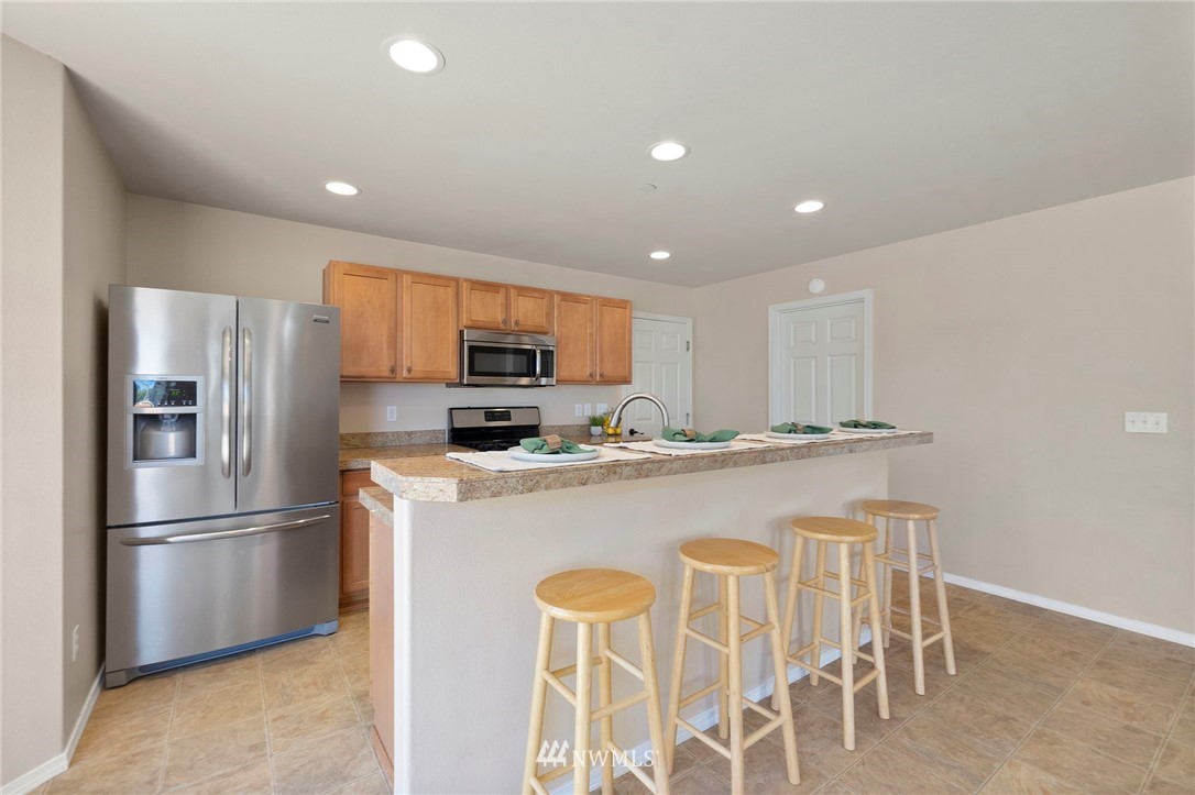 3129 Walker Road DuPont, WA 98327 - Photo 13 of 33 a kitchen with stainless steel appliances granite countertop a refrigerator a stove a sink dishwasher and a refrigerator