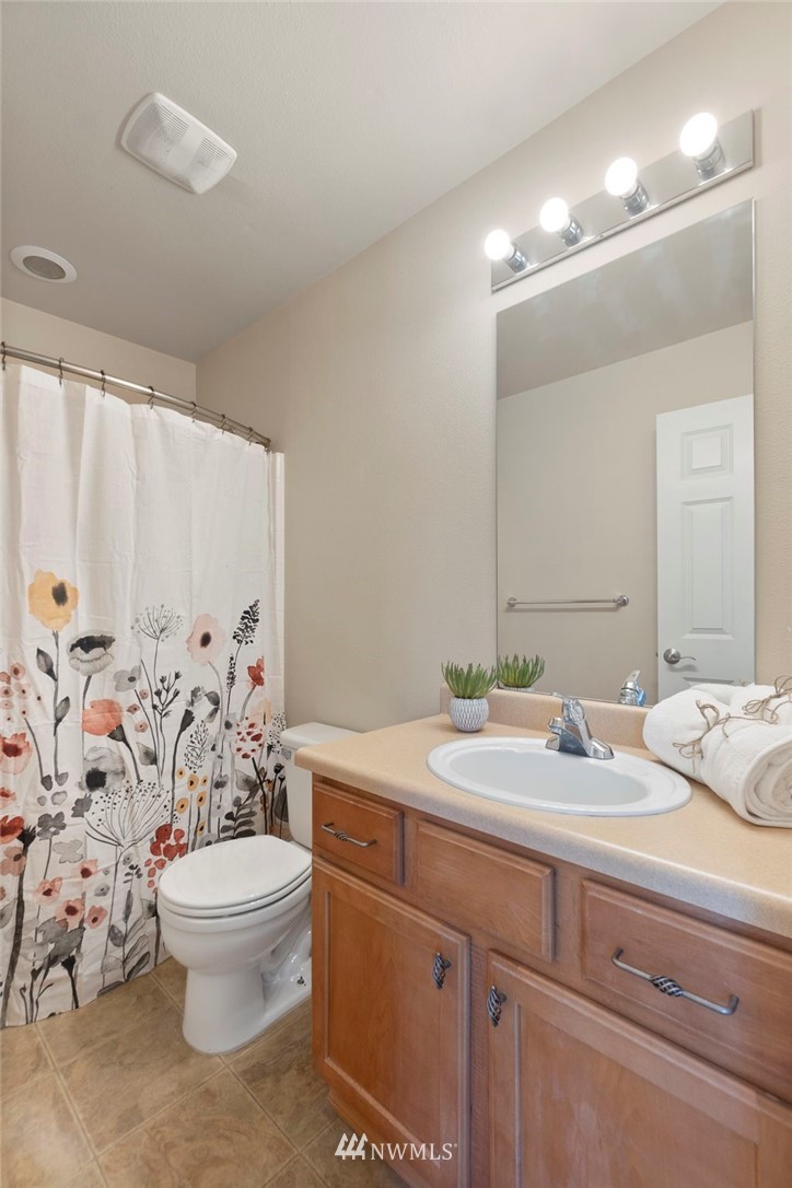 3129 Walker Road DuPont, WA 98327 - Photo 19 of 33 a bathroom with a granite countertop sink a toilet and a mirror