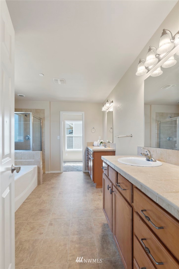 3129 Walker Road DuPont, WA 98327 - Photo 24 of 33 a spacious bathroom with a granite countertop sink a toilet a mirror and bathtub