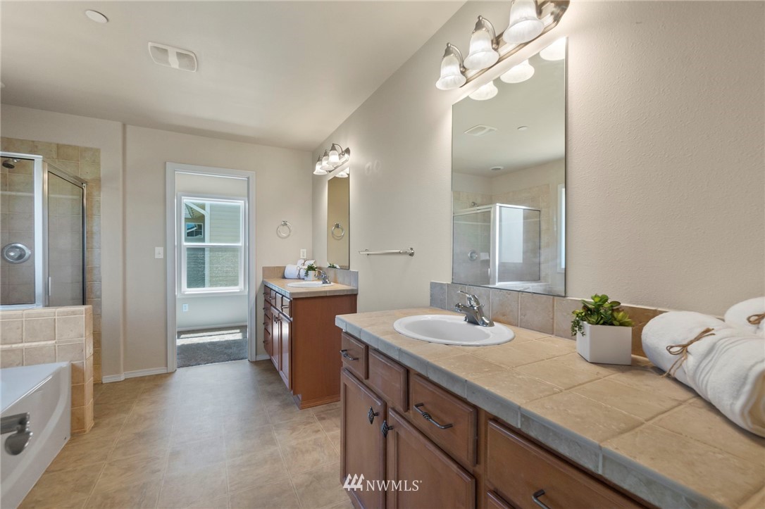 3129 Walker Road DuPont, WA 98327 - Photo 25 of 33 a en suite bathroom with a granite countertop sink and a mirror