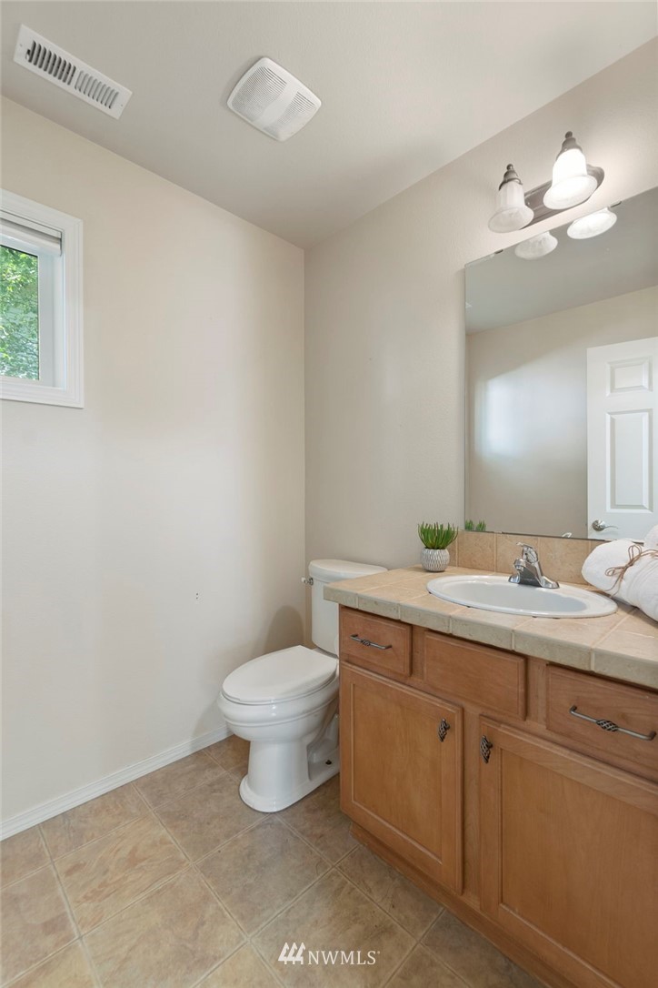 3129 Walker Road DuPont, WA 98327 - Photo 8 of 33 a bathroom with a toilet sink and mirror