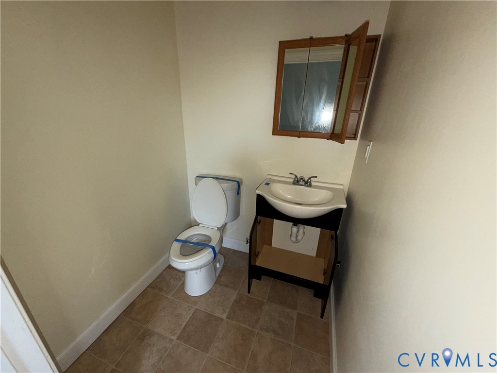 113 West Main Street Wakefield, VA 23888 - Photo 8 of 19 a bathroom with a toilet a sink and mirror