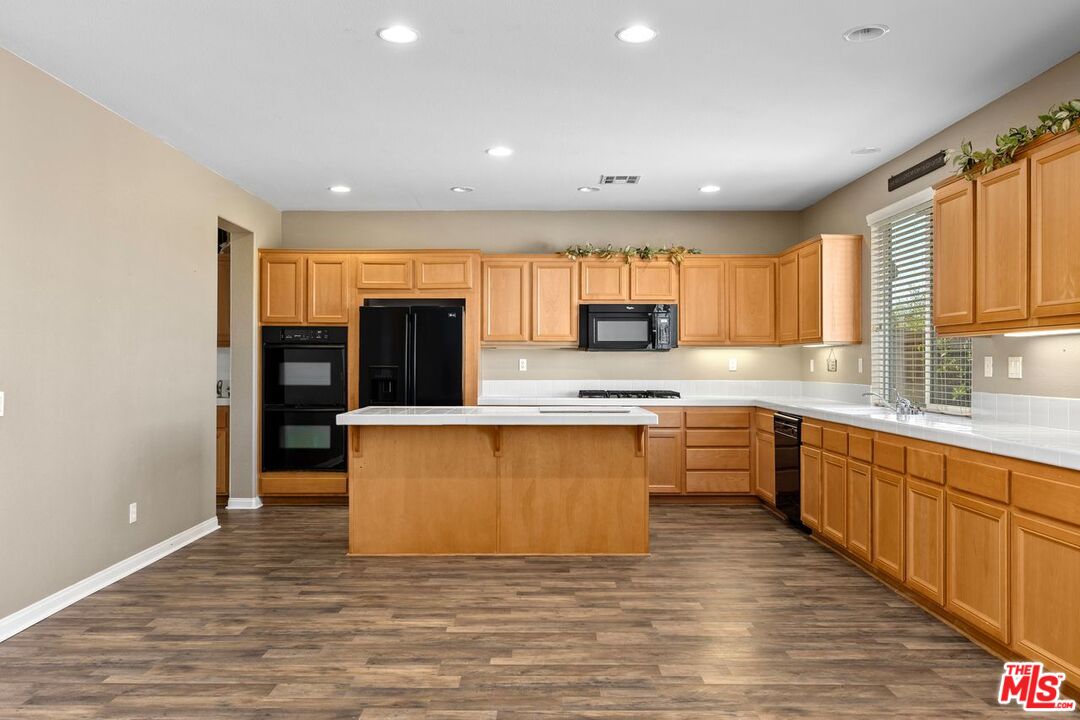 1061 Boulder Place Oceanside, CA 92057 - Photo 3 of 19 a large kitchen with stainless steel appliances granite countertop a stove a sink and a granite counter tops with wooden floors