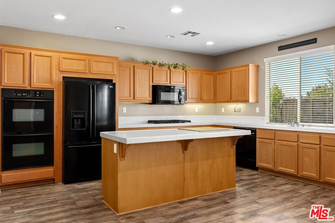 1061 Boulder Place Oceanside, CA 92057 - Photo 4 of 19 a kitchen with stainless steel appliances granite countertop a refrigerator a sink dishwasher a stove and white countertops with wooden floor