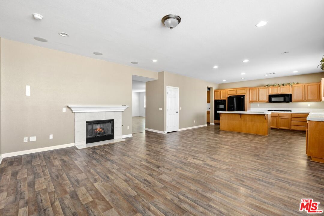 1061 Boulder Place Oceanside, CA 92057 - Photo 7 of 19 an empty room with wooden floor and fireplace