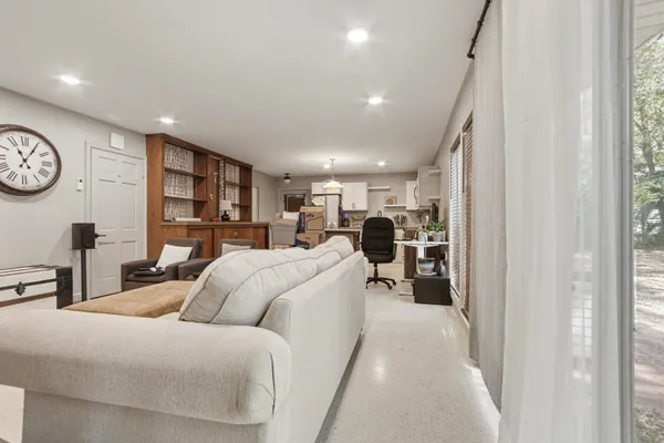 a living room with furniture a clock and a window