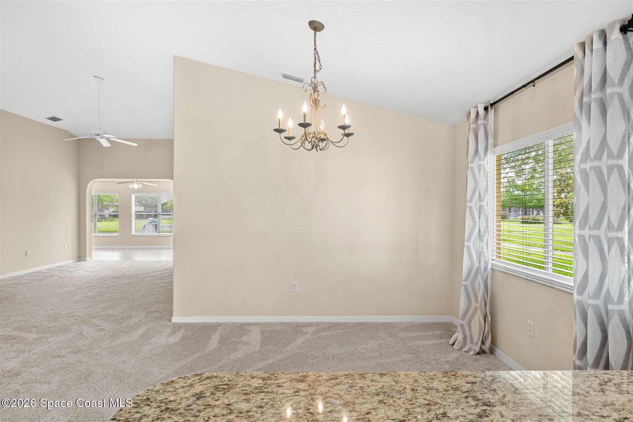 6904 Renshaw Drive Melbourne, FL 32940 - Photo 12 of 46 a view of a chandelier in big room and chandelier