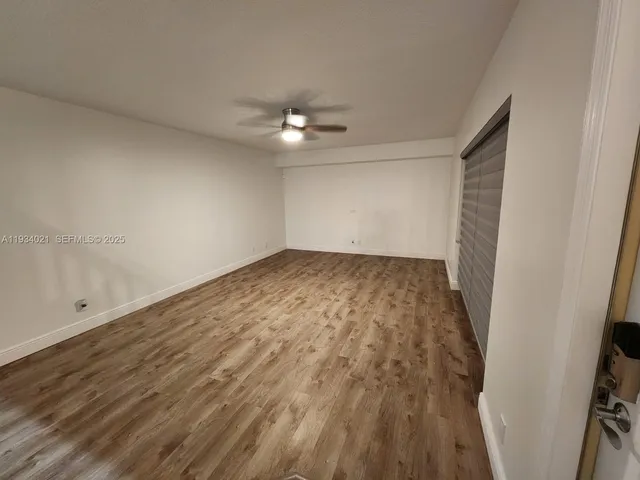 a view of empty room with wooden floor