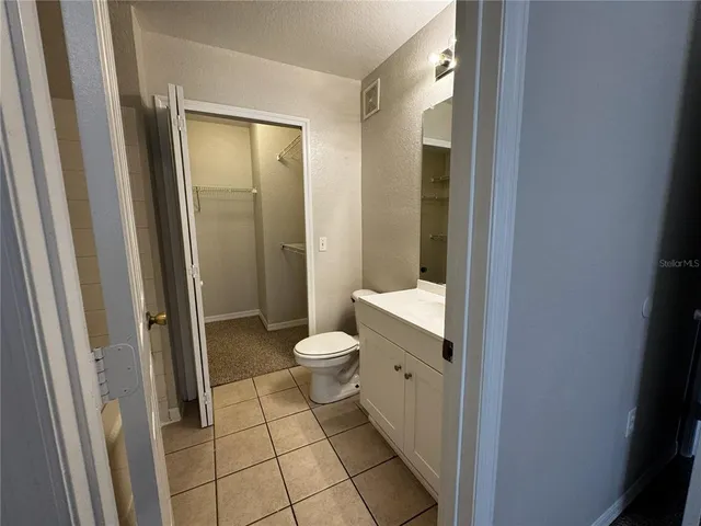 a bathroom with a granite countertop sink mirror and toilet