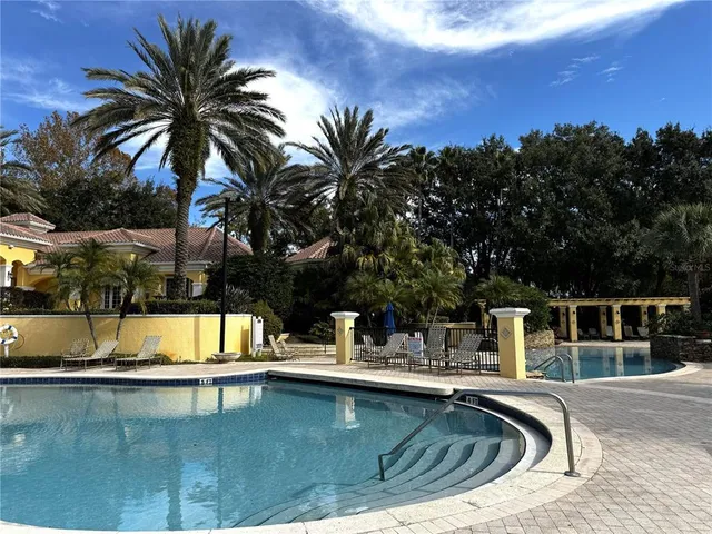 a view of a swimming pool with a lounge chair and palm trees