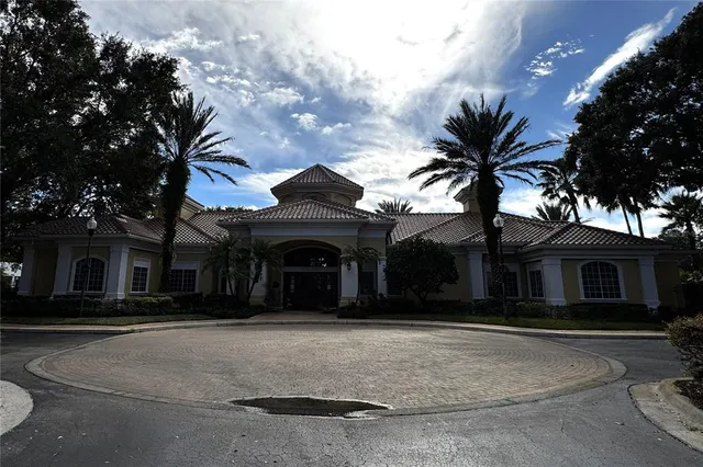 front view of a house with a potted plants and a large tree