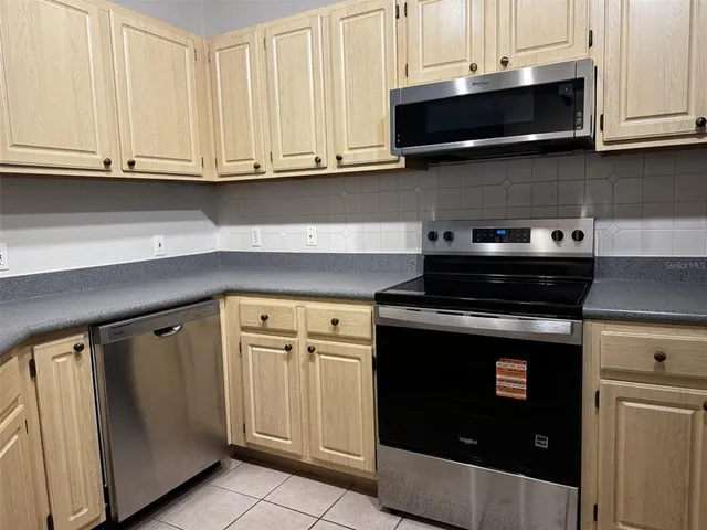 a kitchen with stainless steel appliances granite countertop a stove a microwave and cabinets