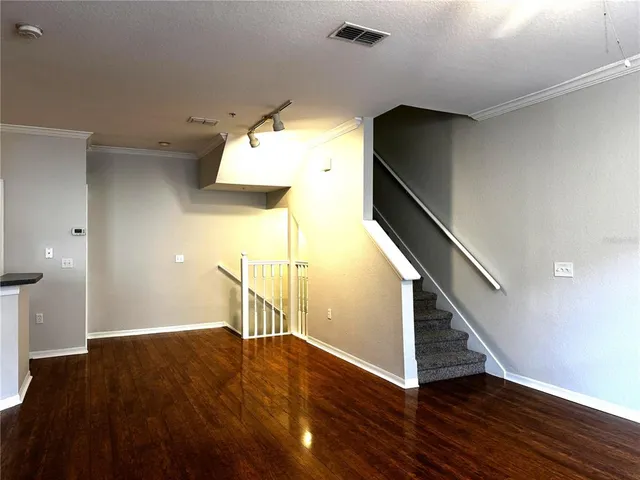 a view of a hallway with wooden floor and staircase