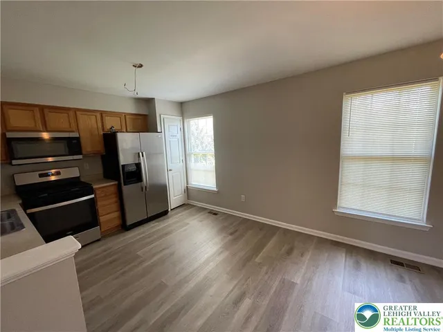 a view of kitchen with wooden floor electronic appliances and window