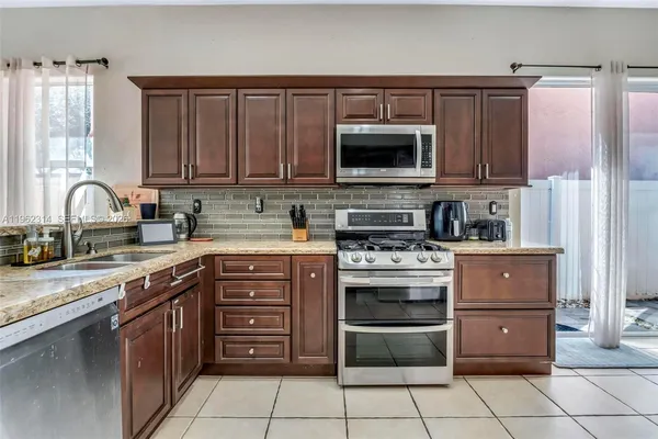 a kitchen with stainless steel appliances granite countertop a stove microwave and cabinets