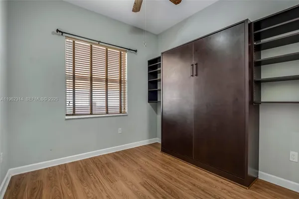 an empty room with wooden floor and windows