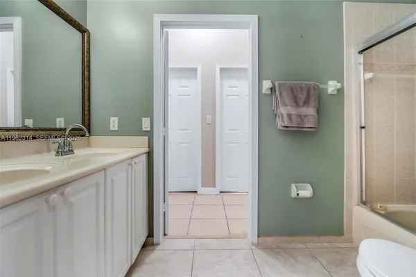 a bathroom with a granite countertop sink a toilet and mirror