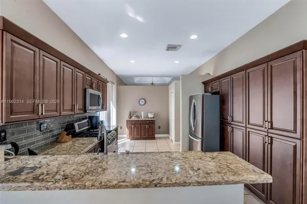 a kitchen with stainless steel appliances granite countertop a refrigerator and a sink