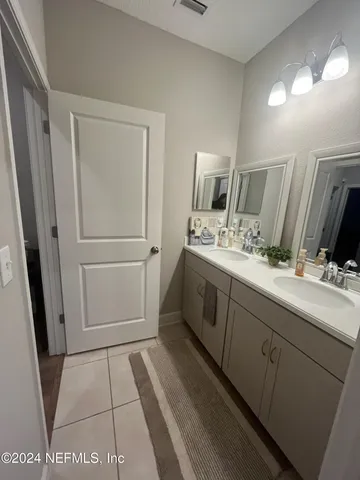 a bathroom with a double vanity sink and mirror