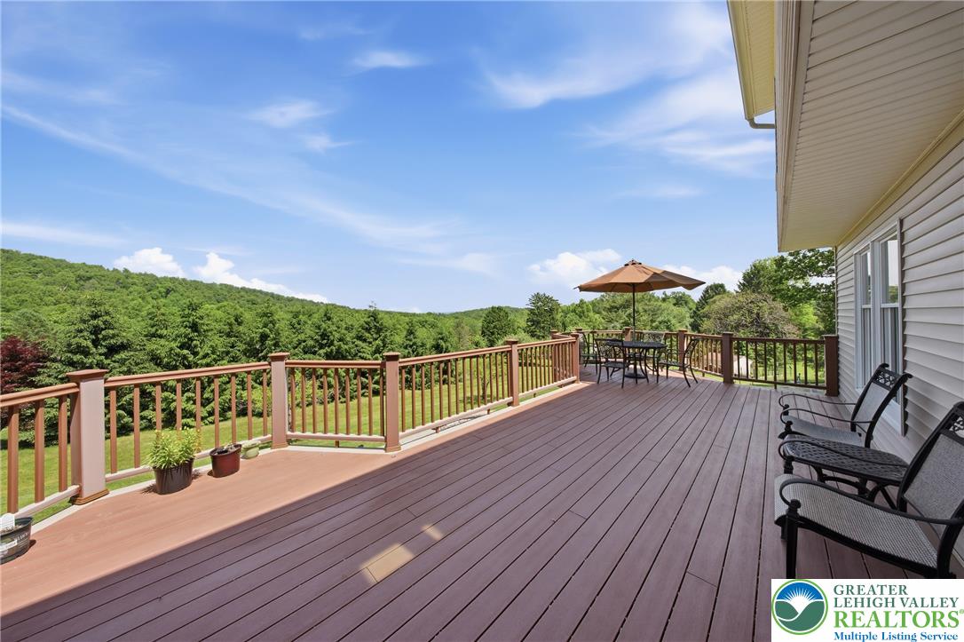 115 West Butternut Road Hellertown, PA 18055 - Photo 62 of 97 An inviting deck extends from the home, presenting a serene vista of rolling, tree-covered hills.