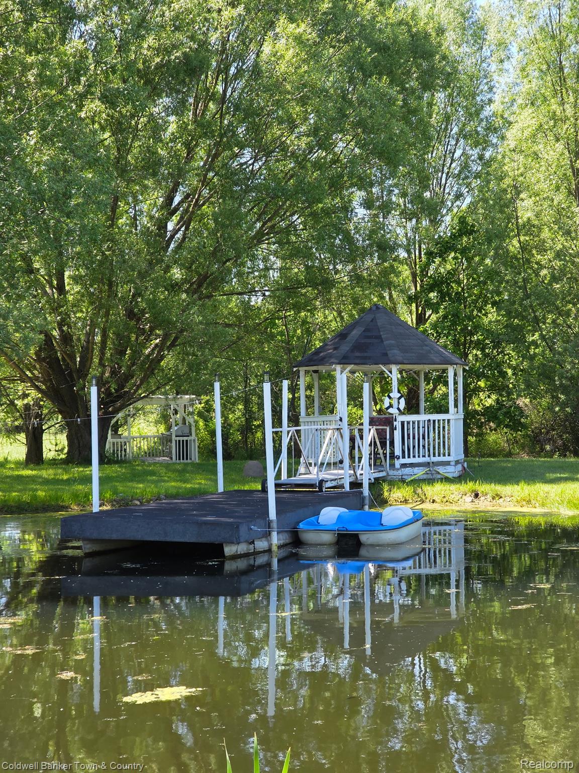 717 North Youngs Road Attica, MI 48412 - Photo 76 of 87 Pondside gazebo featuring a dark shingled roof, white balusters, and a floating dock