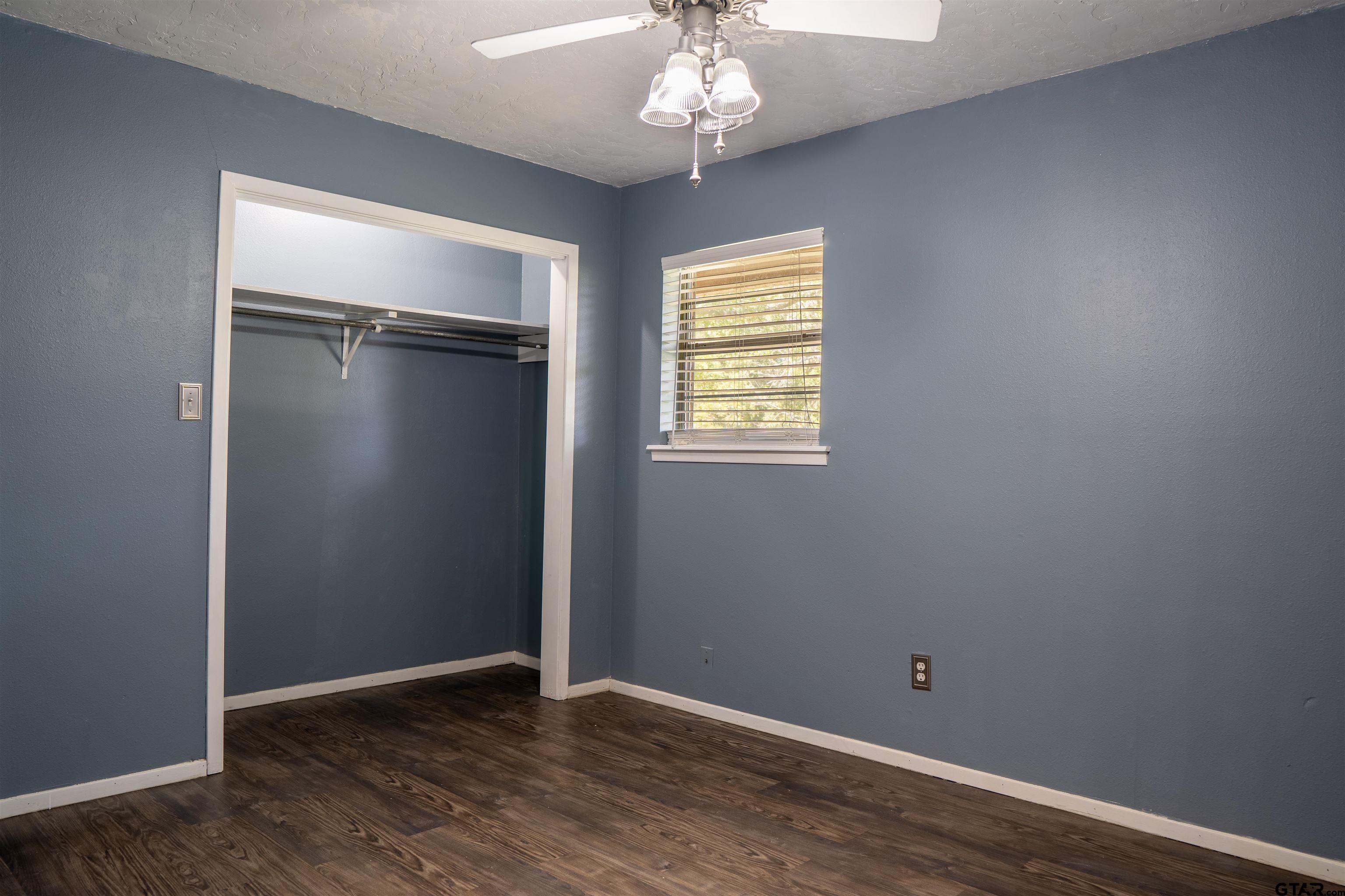 4006 Mark Lane Mount Pleasant, TX 75455 - Photo 17 of 28 an empty room with wooden floor and windows