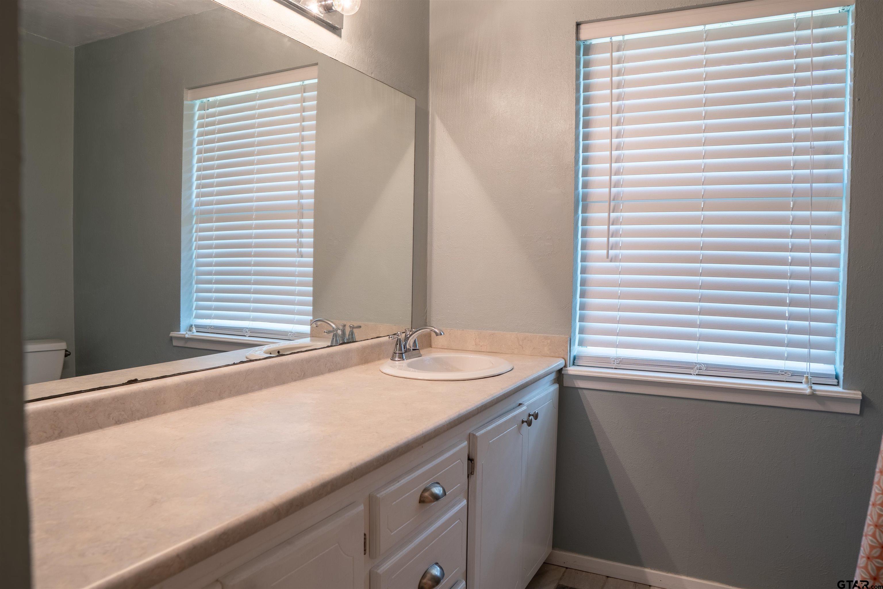 4006 Mark Lane Mount Pleasant, TX 75455 - Photo 19 of 28 a bathroom with a granite countertop sink and a window