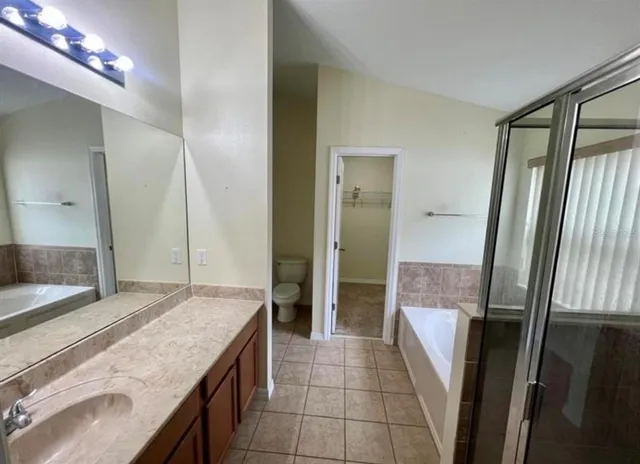 a bathroom with a granite countertop sink a large mirror and a shower